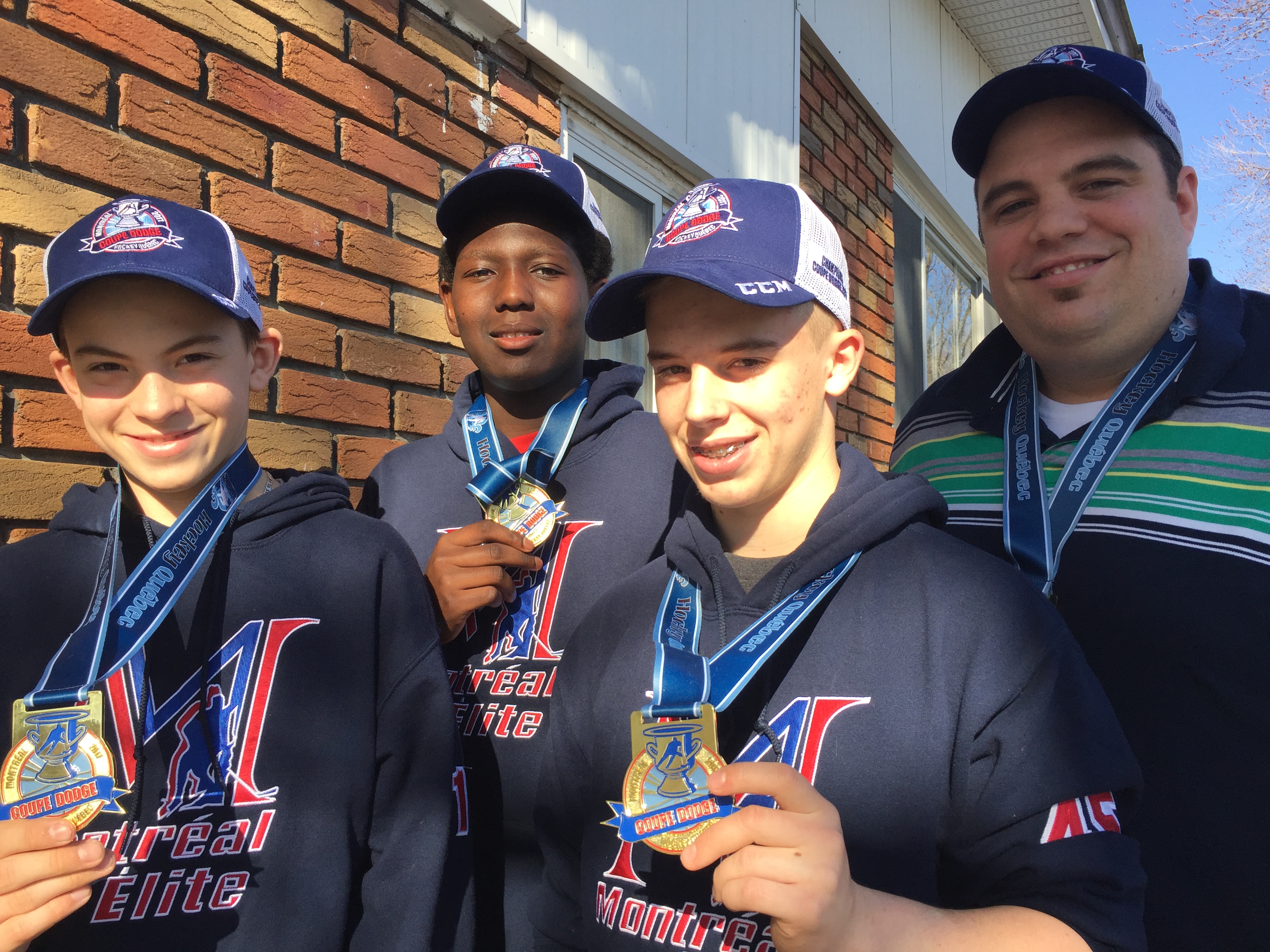 (de g. à d.) Benjamin Boon, Kevin Pouliot et Andrew Auguste exhibent leurs médailles de la Coupe Dodge 2017, en compagnie de l'entraîneur Guillaume Piché.