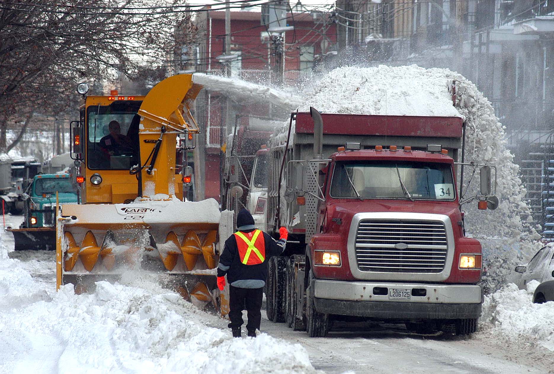 Un camion et une souffleuse pendant une opération de chargement de la neige à Montréal