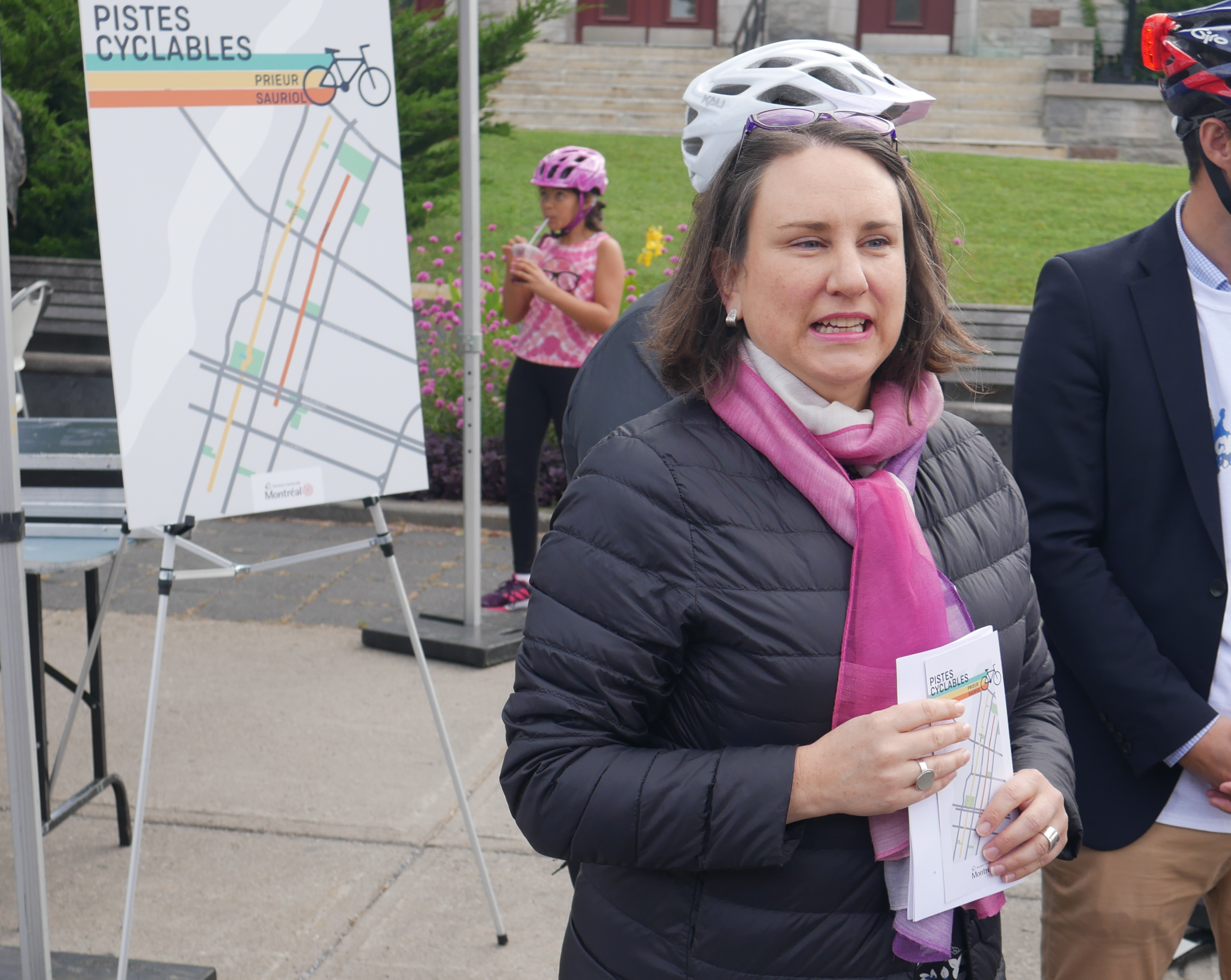 Émilie Thuillier devant un panneau présentant les nouvelles pistes cylables