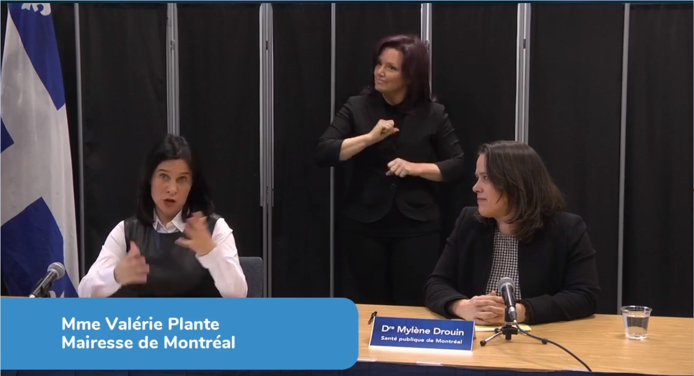 L'interprète Brigitte Giguère à l'oeuvre durant un point de presse accompagné de la mairesse Valérie Plante et la Dre Mylène Drouin