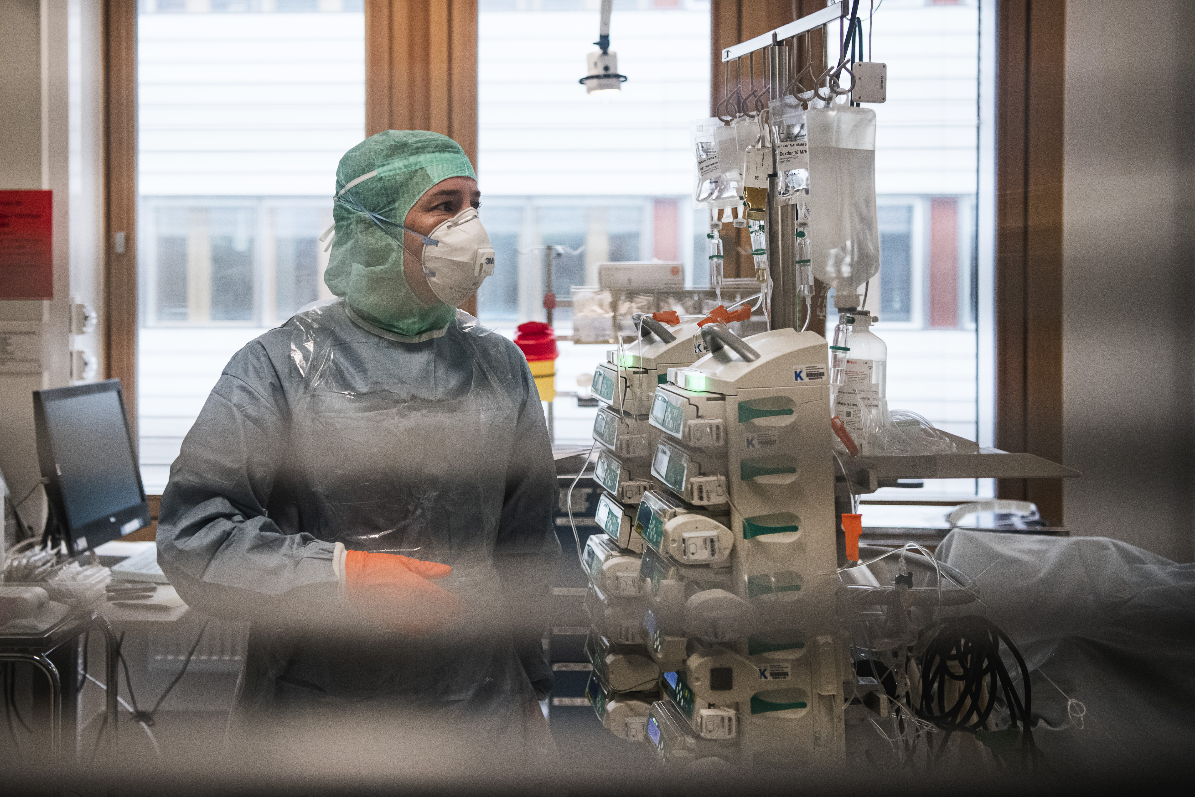 Une personne du corps médical porte une blouse de protection et un masque.