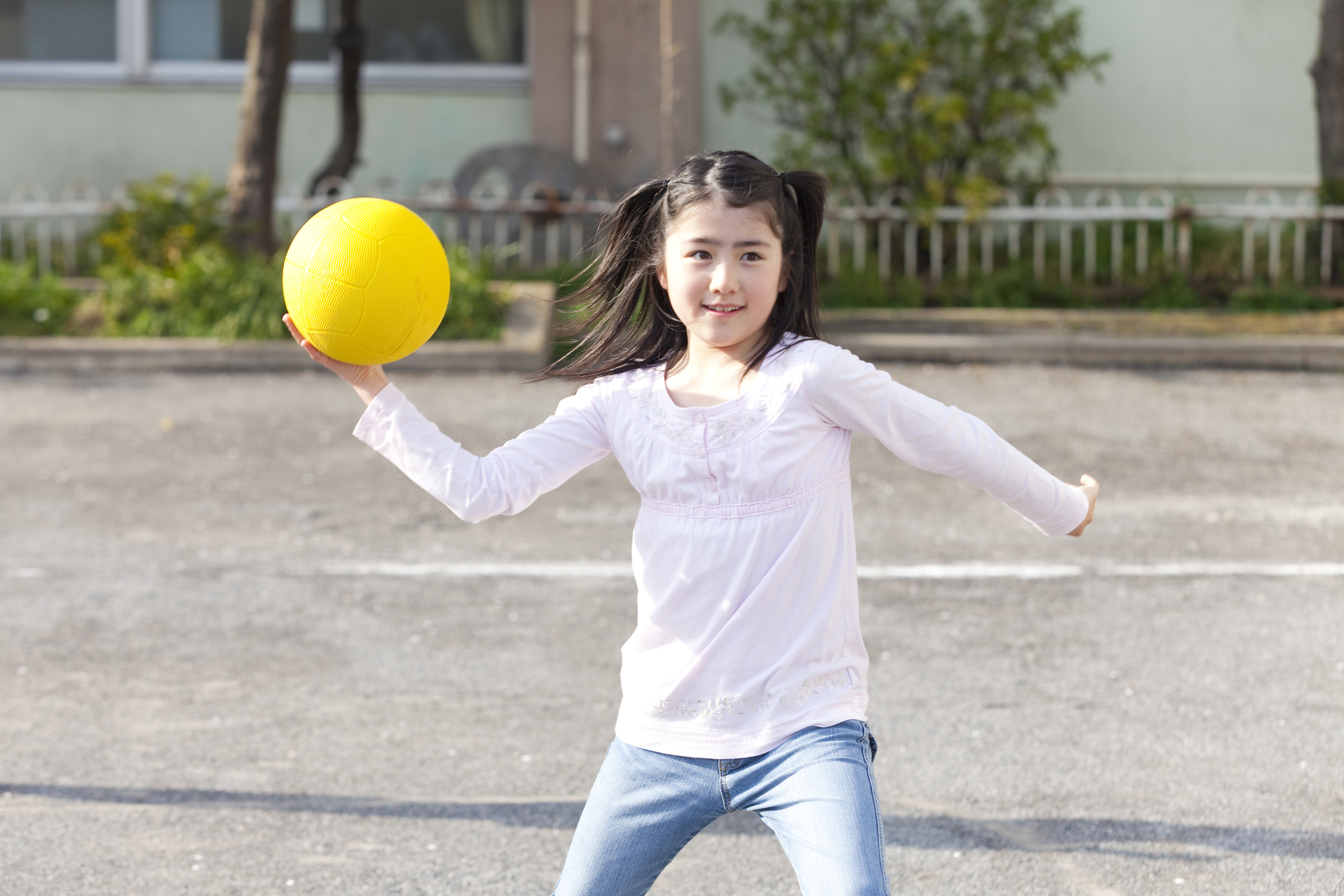 Une jeune fille joue au ballon-chasseur.