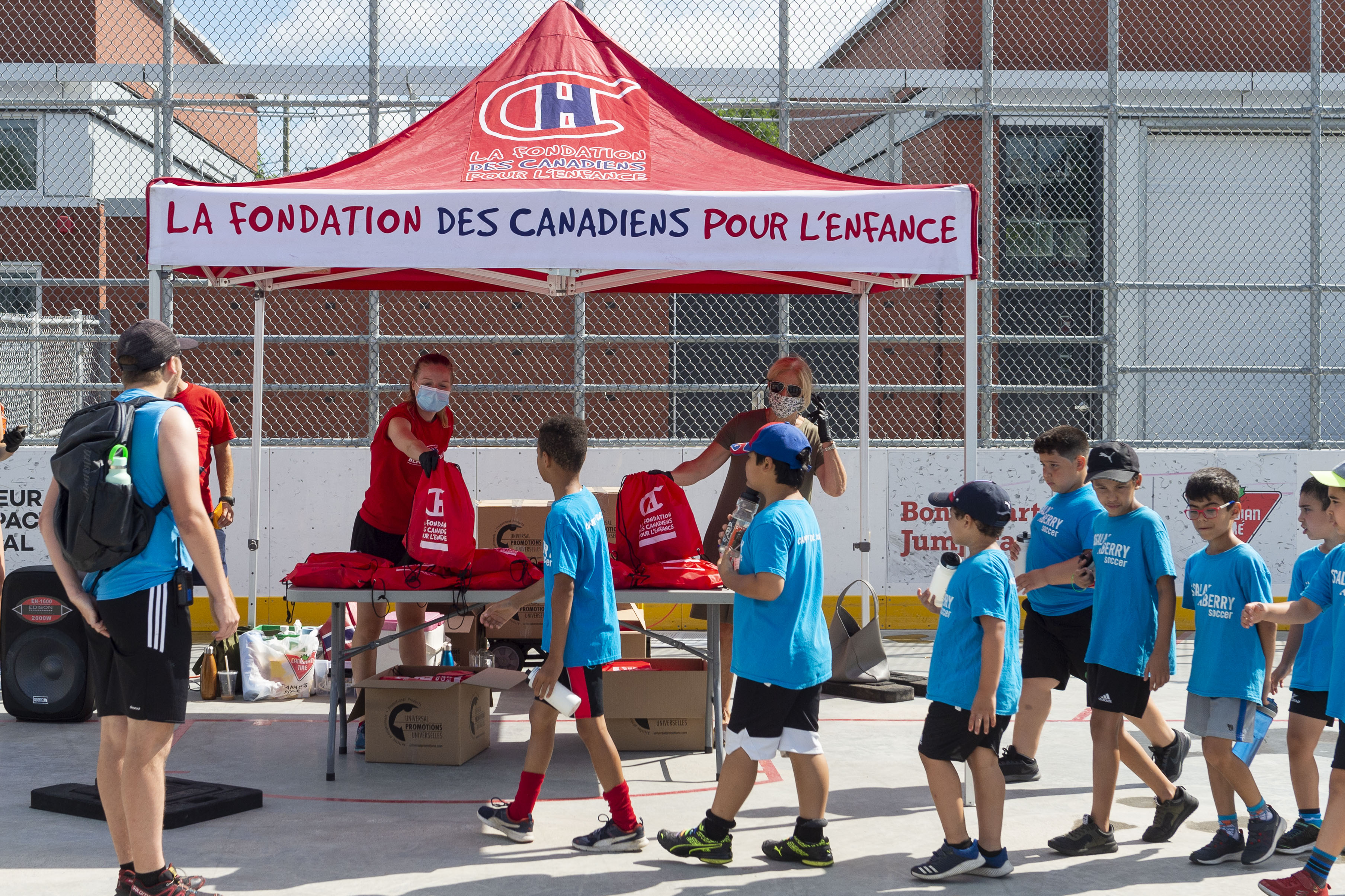 Des jeunes attendent en ligne avant de recevoir leur trousse.