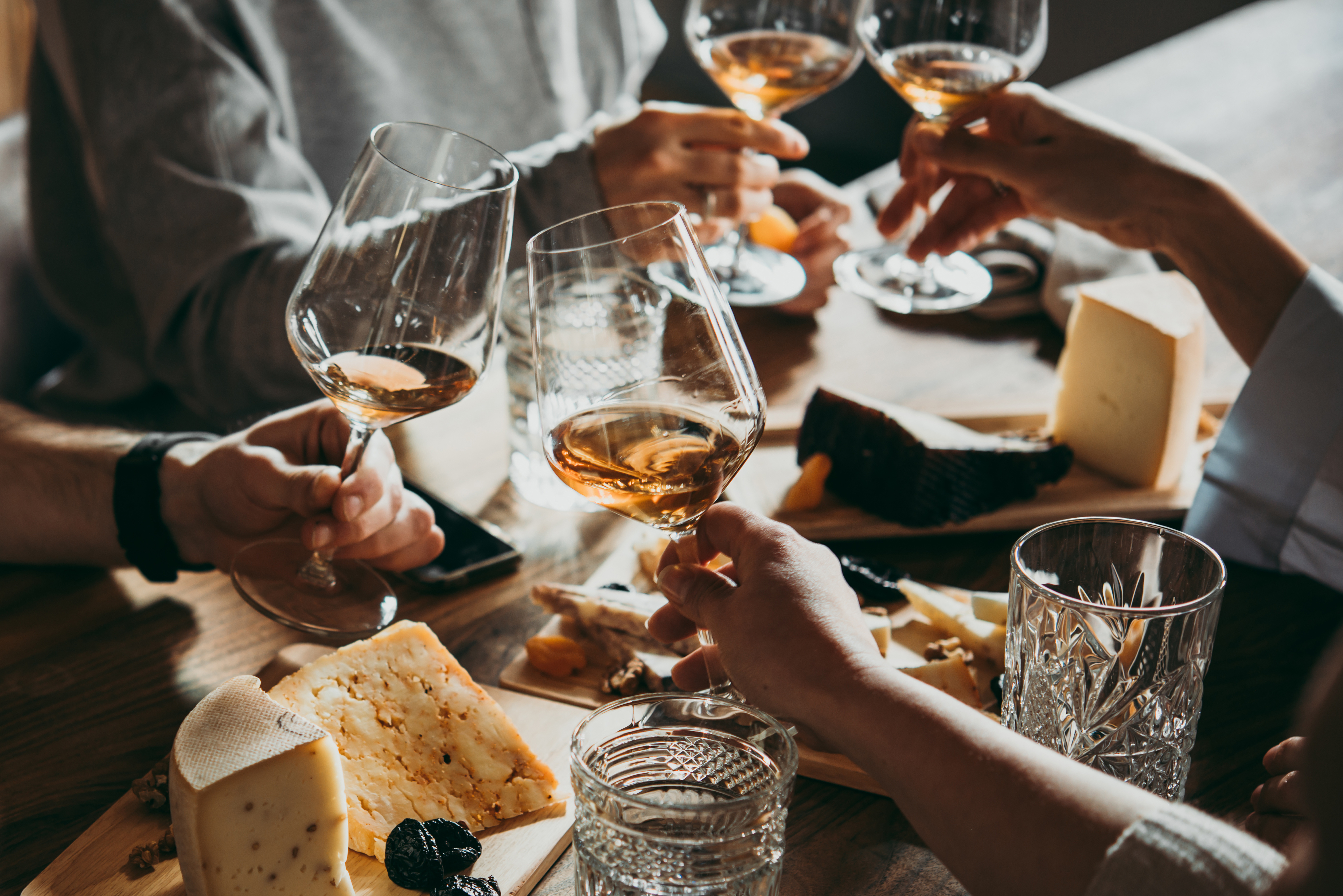 Vin et fromage pour des amis qui trinquent