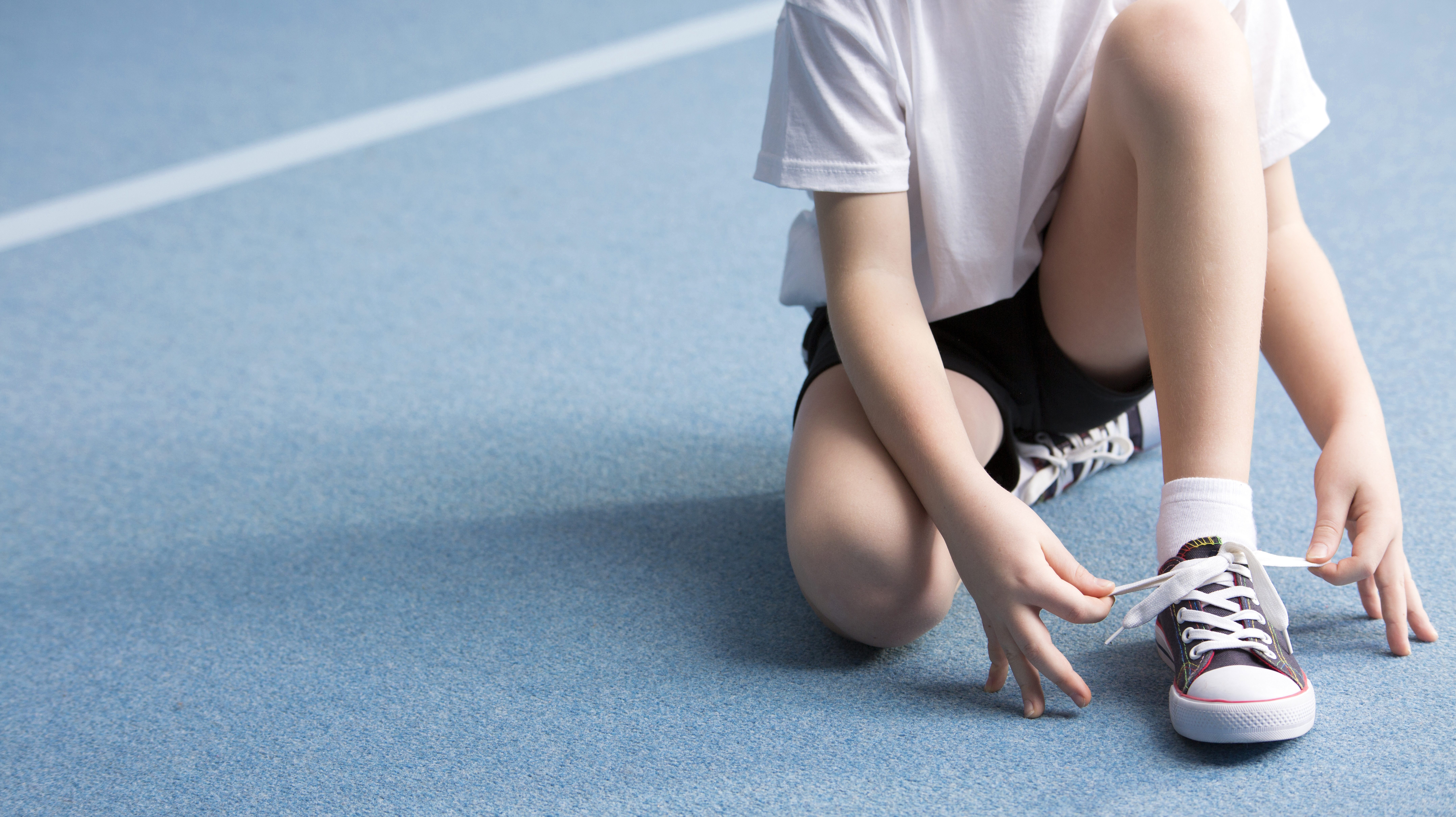 Adolescent attachant son lacet d'espadrille