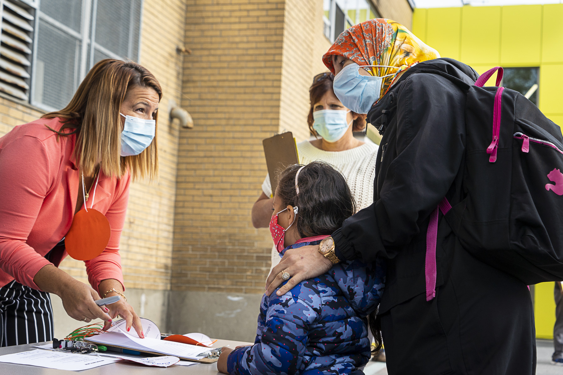 Une enfant masquée est accueillie avec sa mère à l'école primaire Philippe-Labarre, lors de la première rentrée scolaire depuis le début de la pandémie de COVID-19.