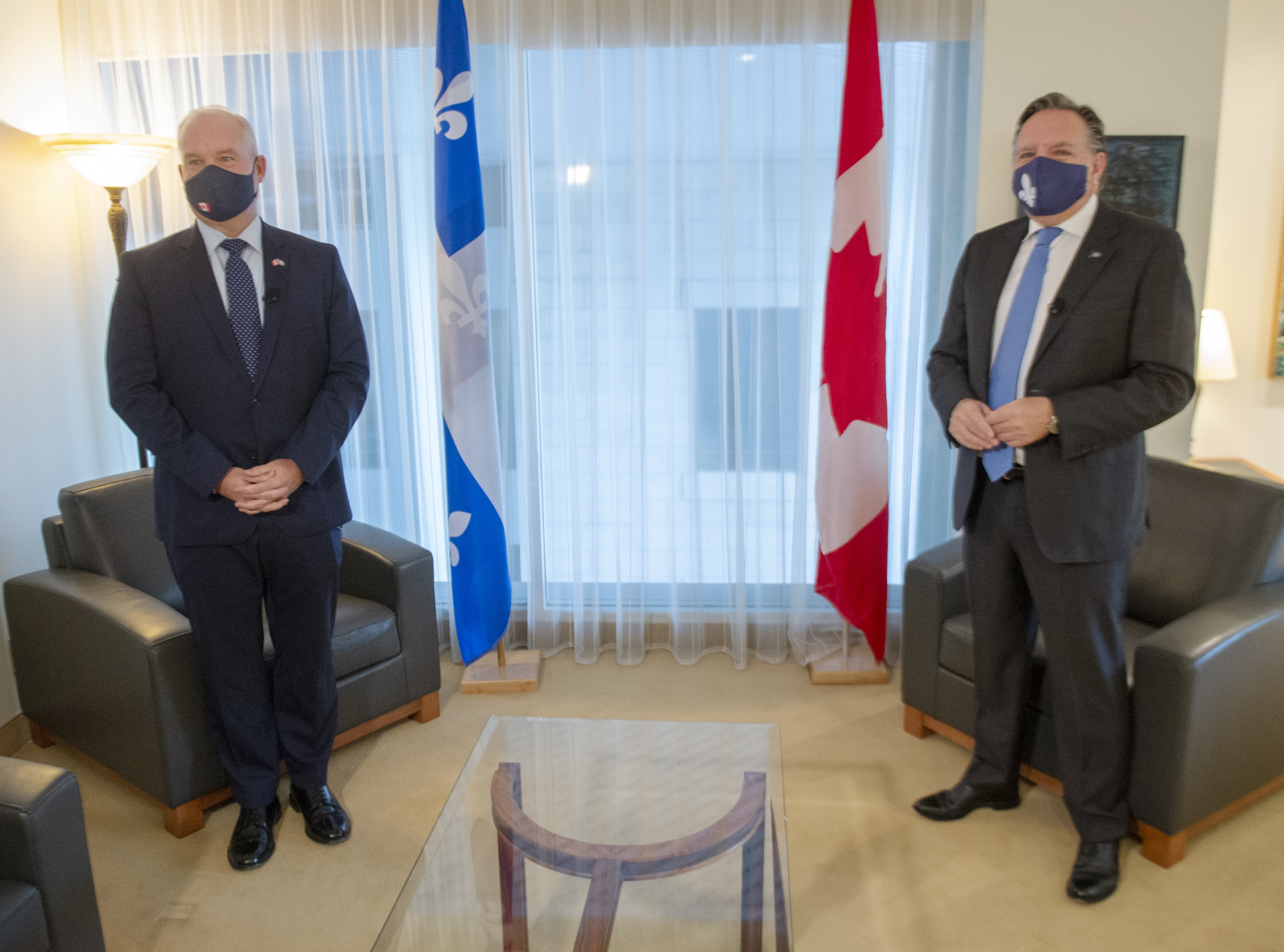 Erin O'Toole et François Legault devant des drapeaux du Québec et du Canada, portant des masques.