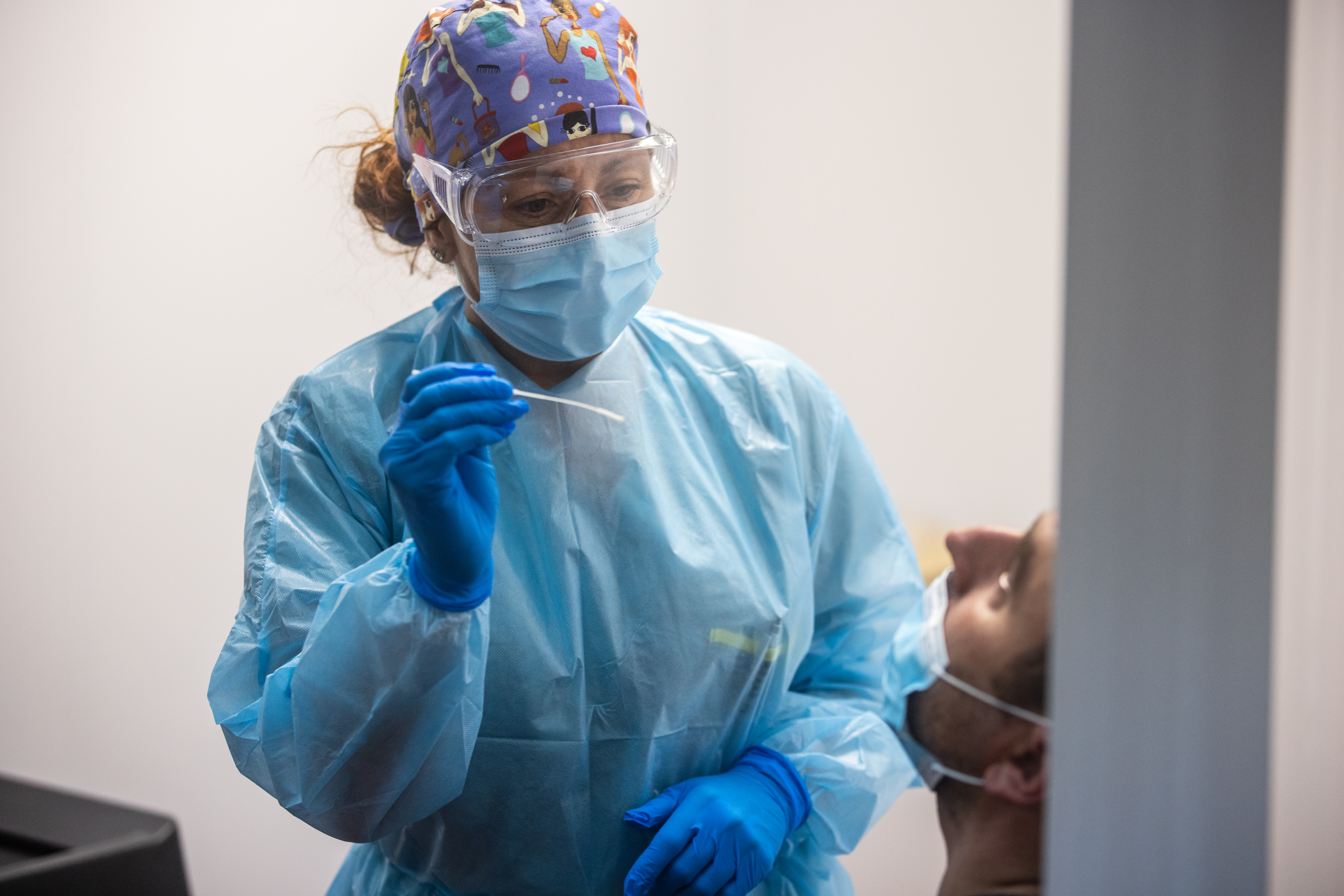 Une infirmière masquée procède à un test de dépistage du coronavirus.