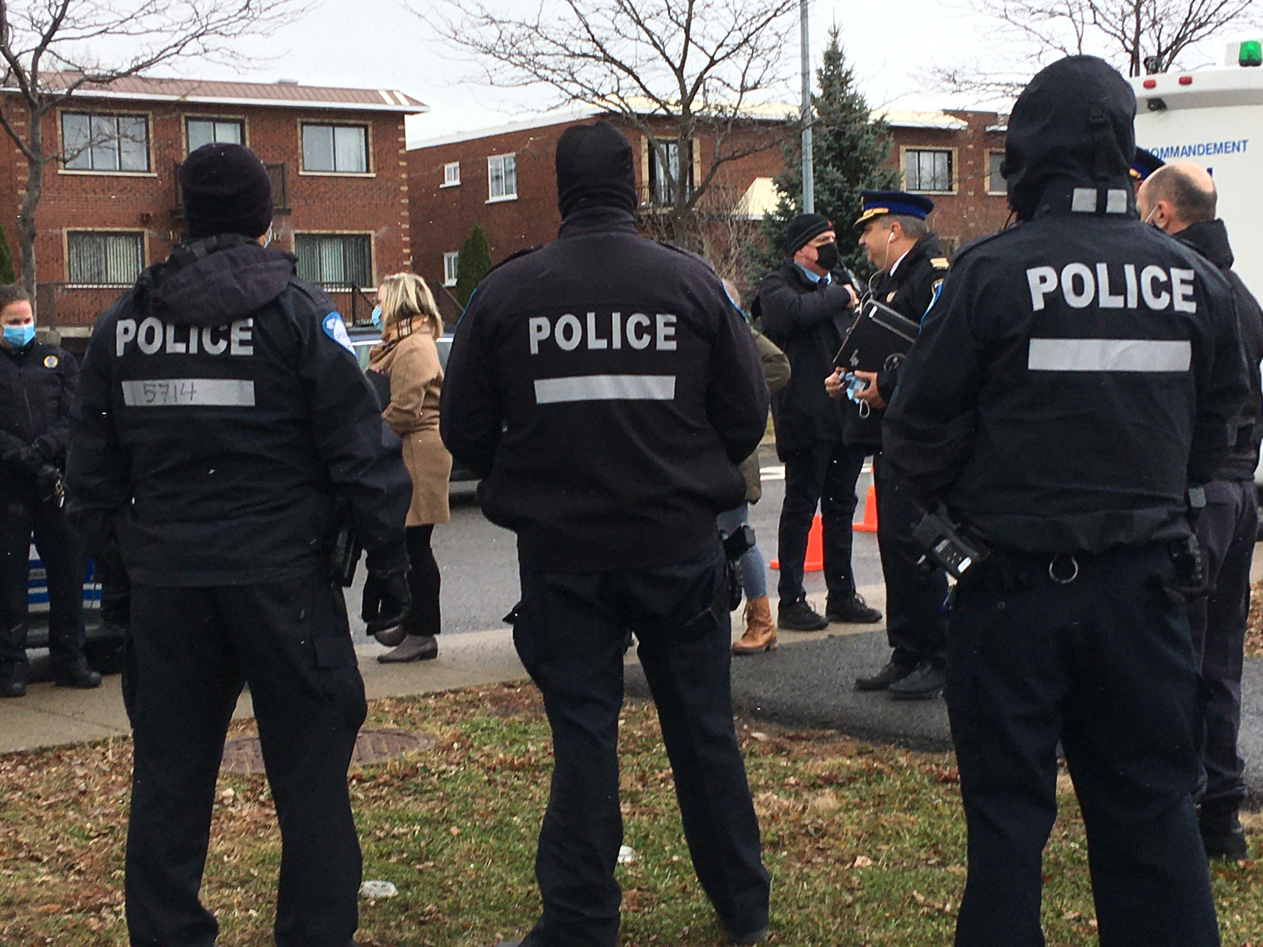 Des policiers de dos à Rivière-des-Prairies.