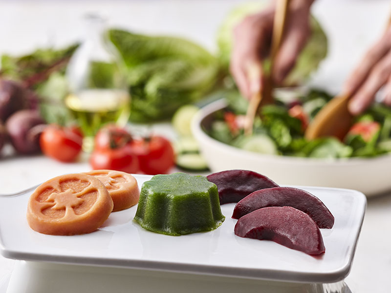 Aliments mous moulés en forme de tomate et autres légumes.