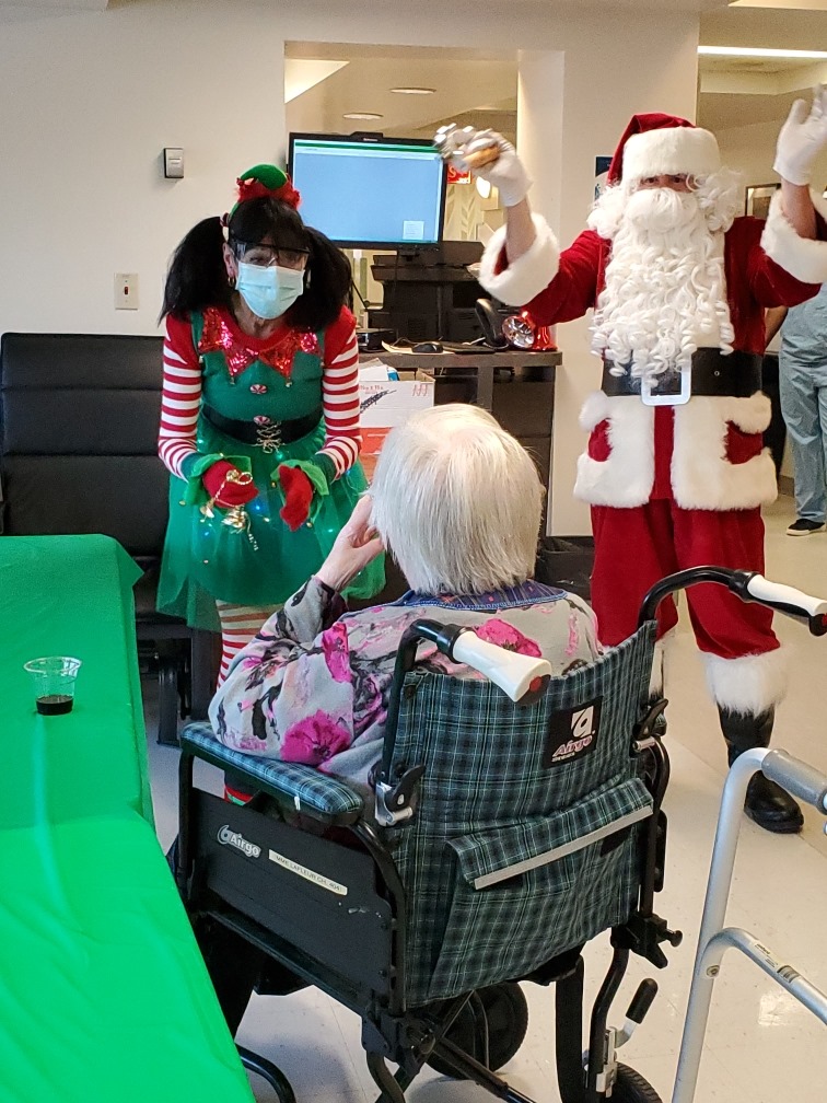 Une résidente du CHSLD Manoir de Verdun est ravie de voir le père Noël.