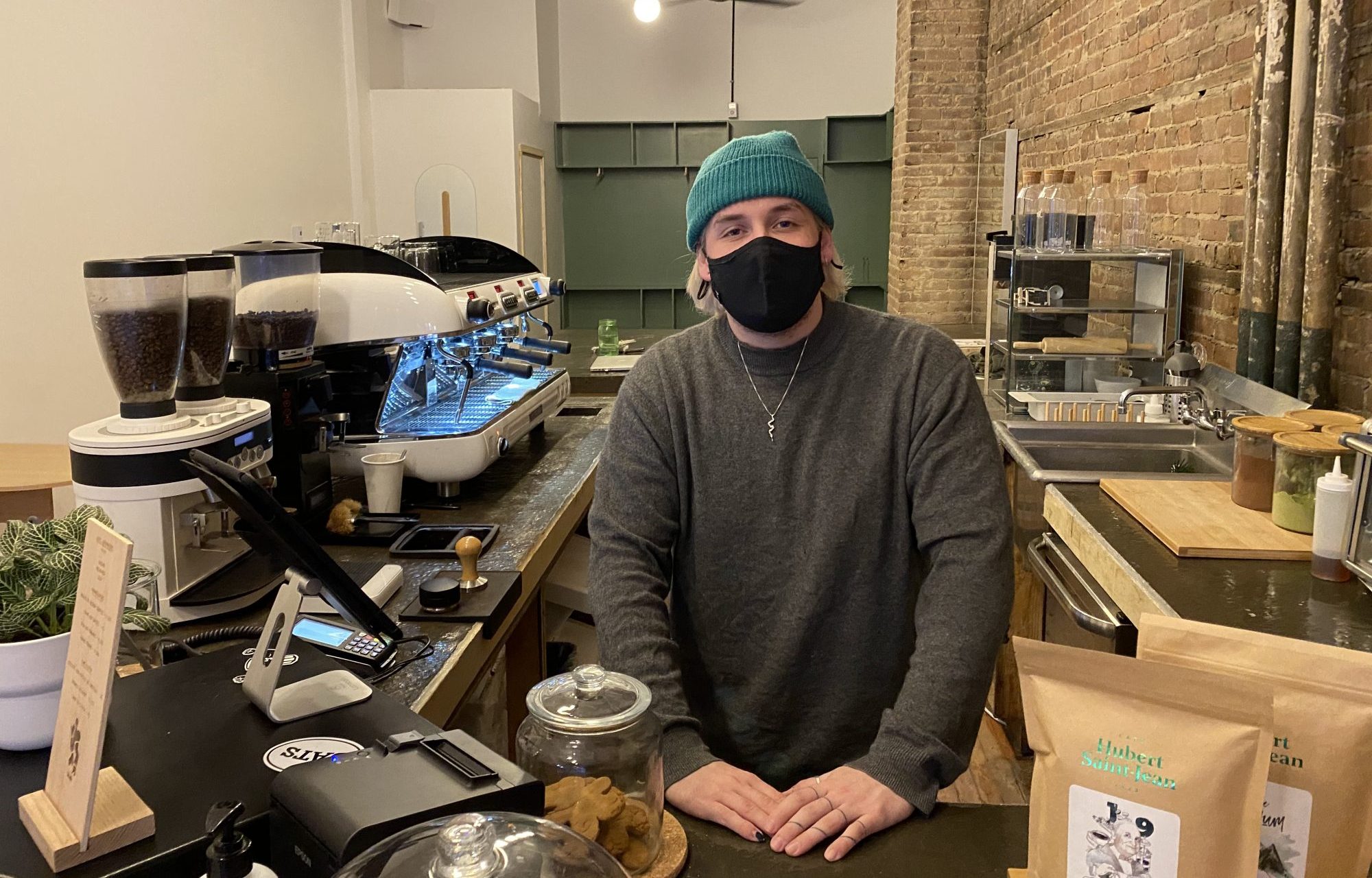 Un des propriétaires du café Venelle, Jules Bonneville-Coulombe, derrière le comptoir de son commerce.