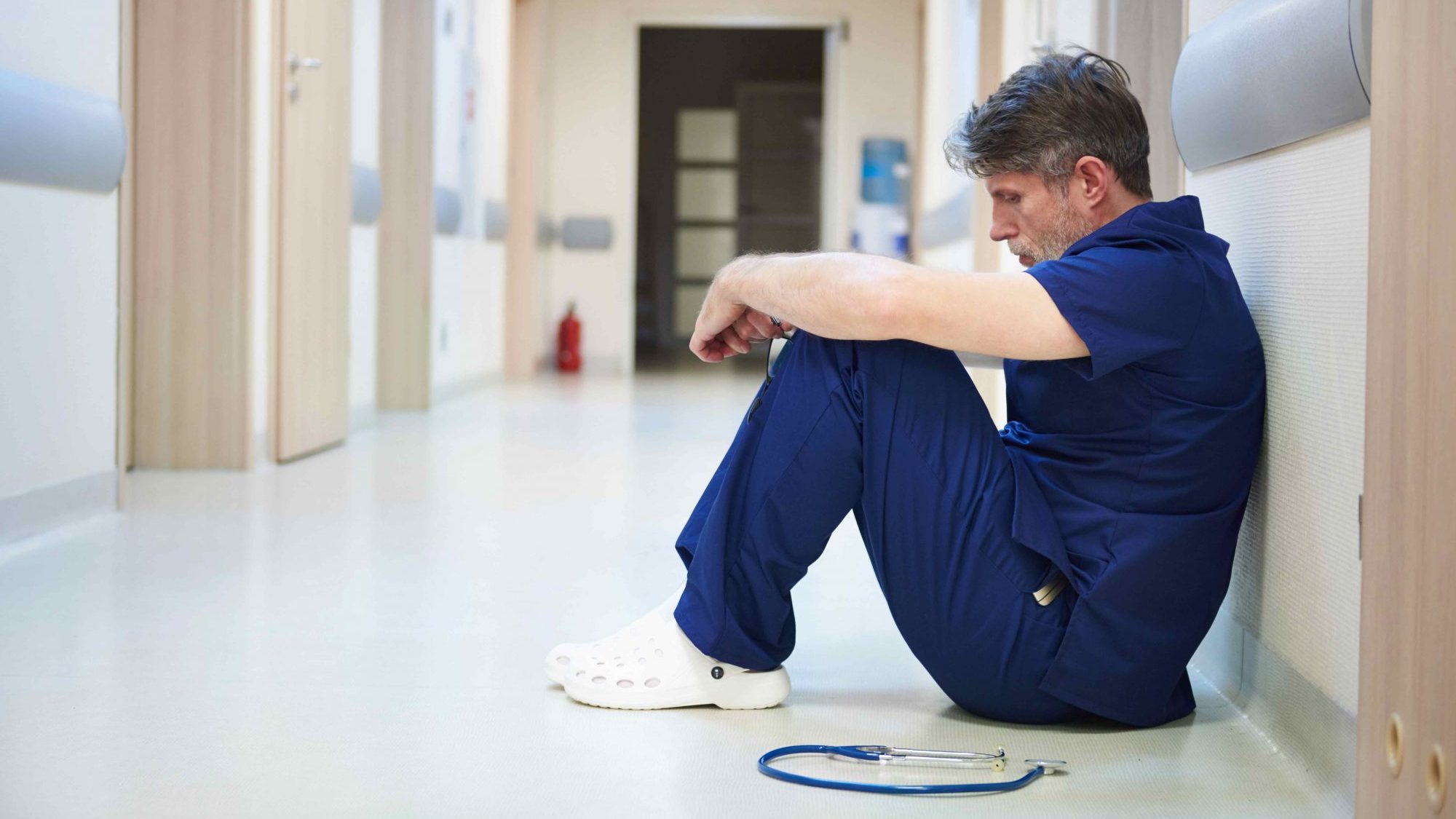 Infirmier assis seul dans le corridor d'un hôpital