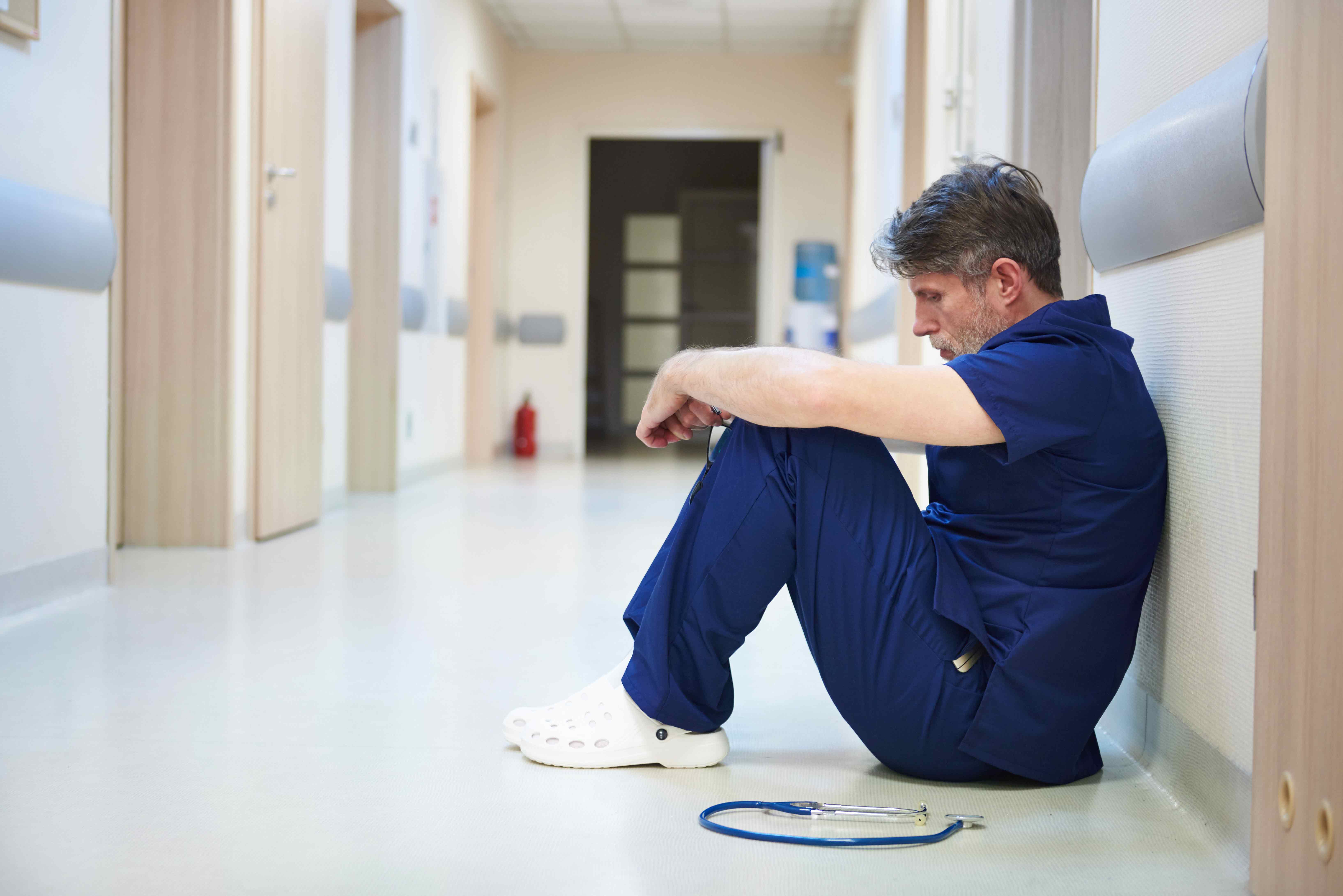 Infirmier assis seul dans le corridor d'un hôpital