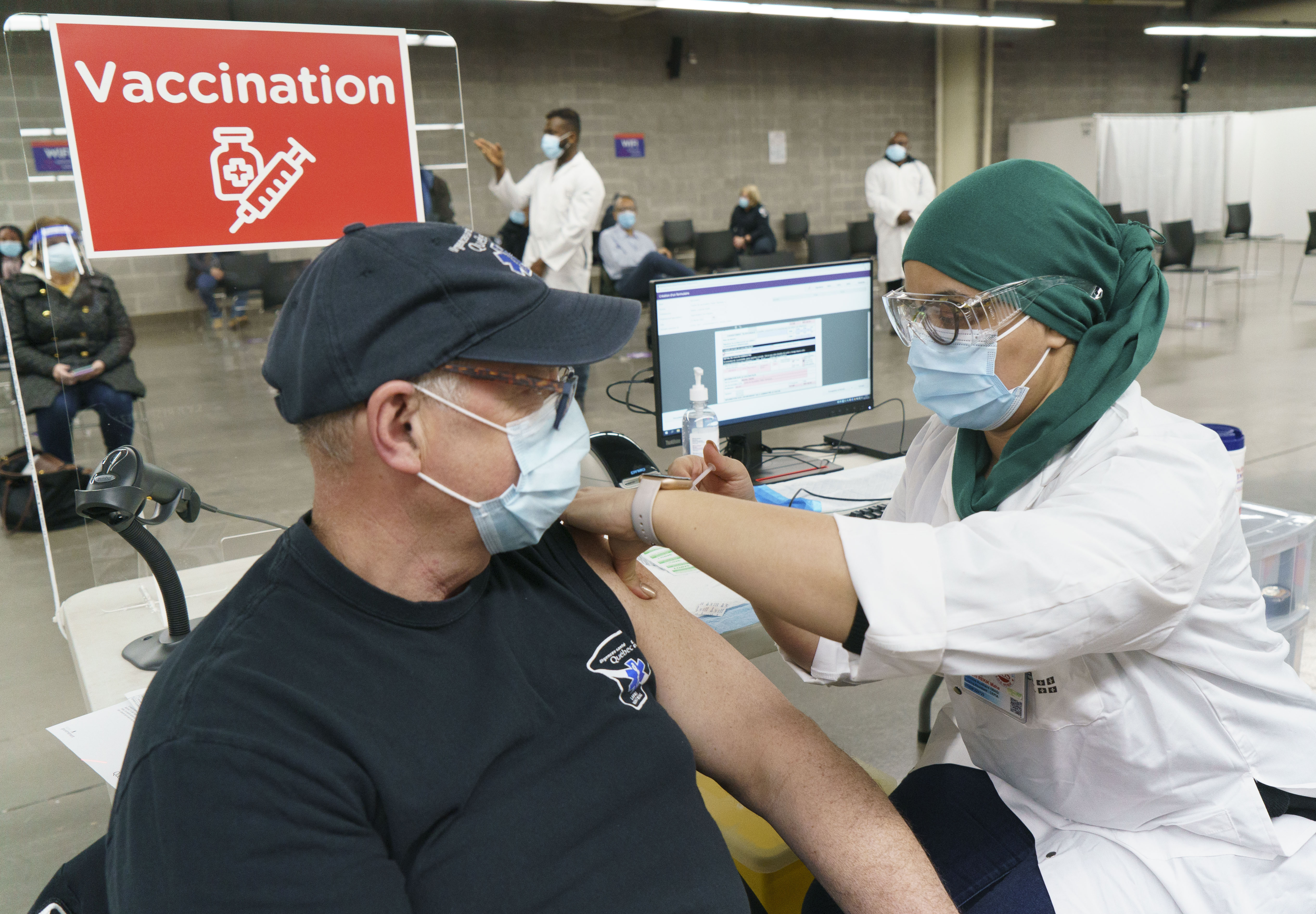 Un homme reçoit un vaccin à la clinique de vaccination du Stade olympique de Montréal.