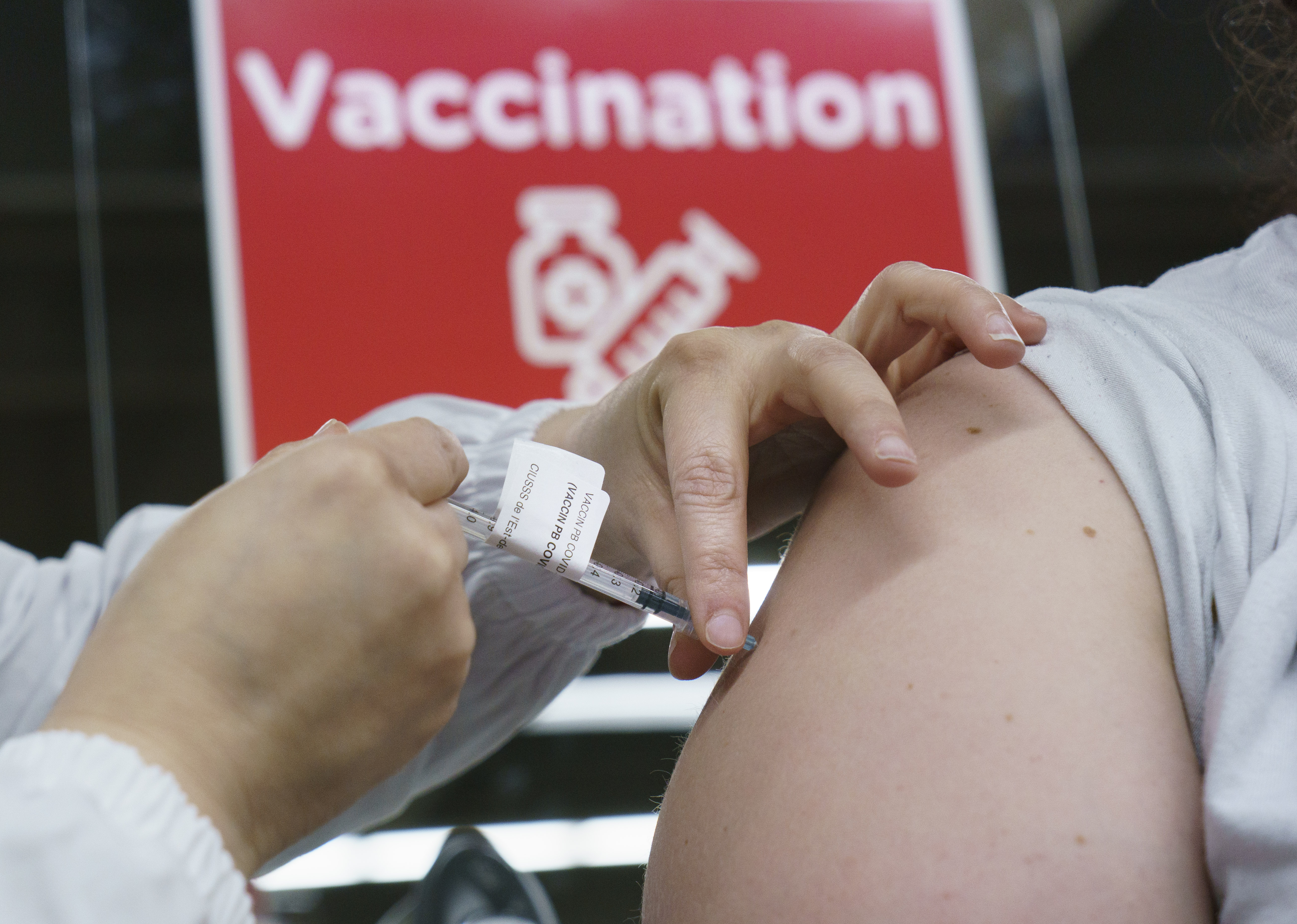 Une personne administre une dose de vaccin dans une clinique de vaccination