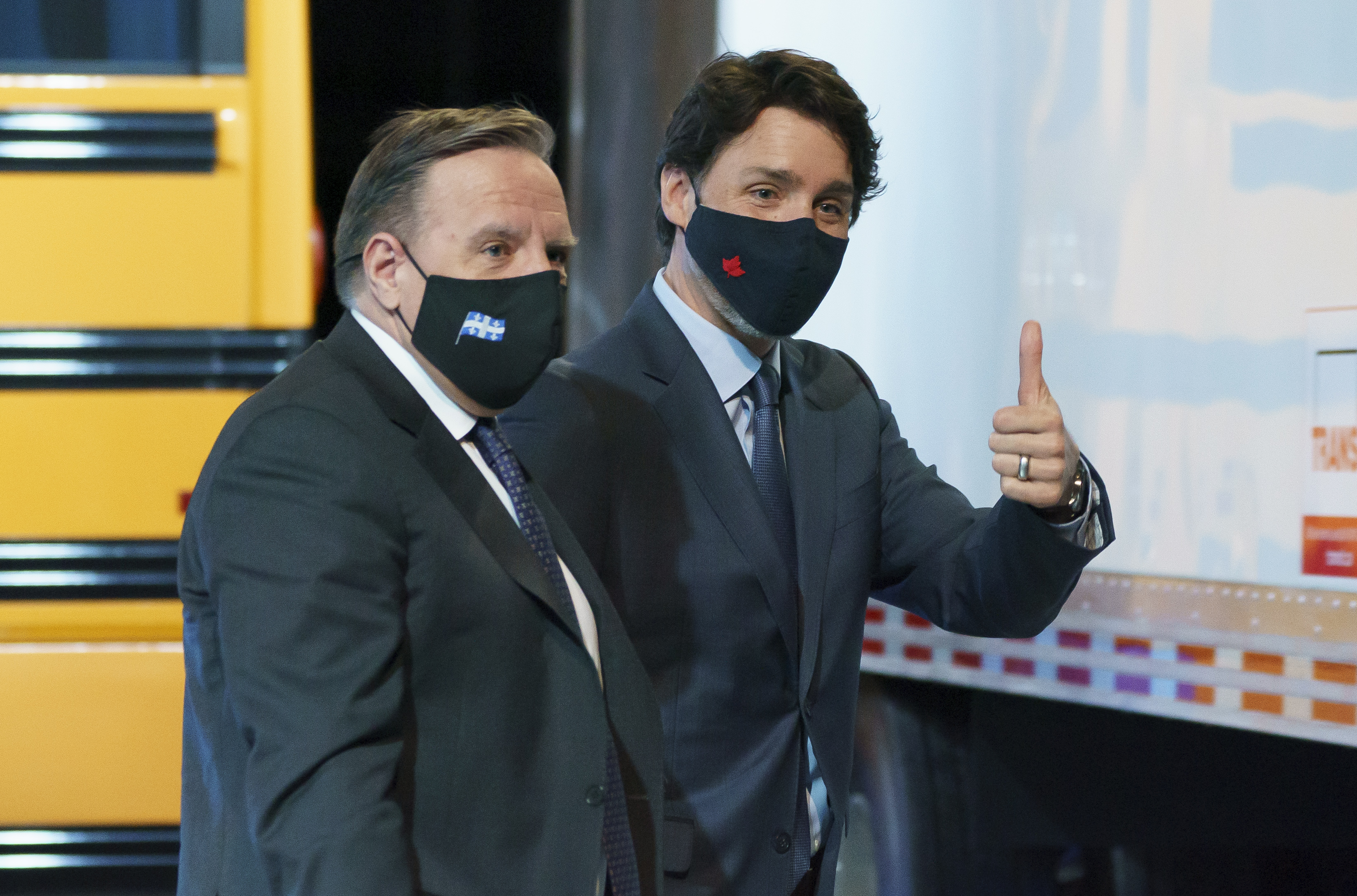 François Legault et Justin Trudeau devant un autobus jaune