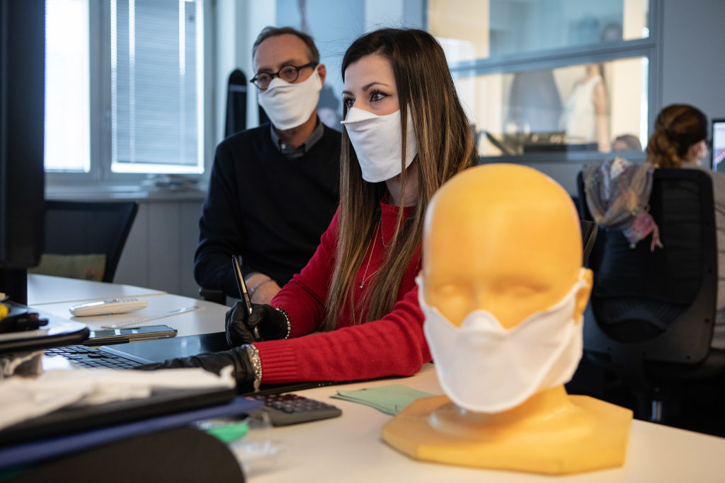 Des employés portent le masque médical.