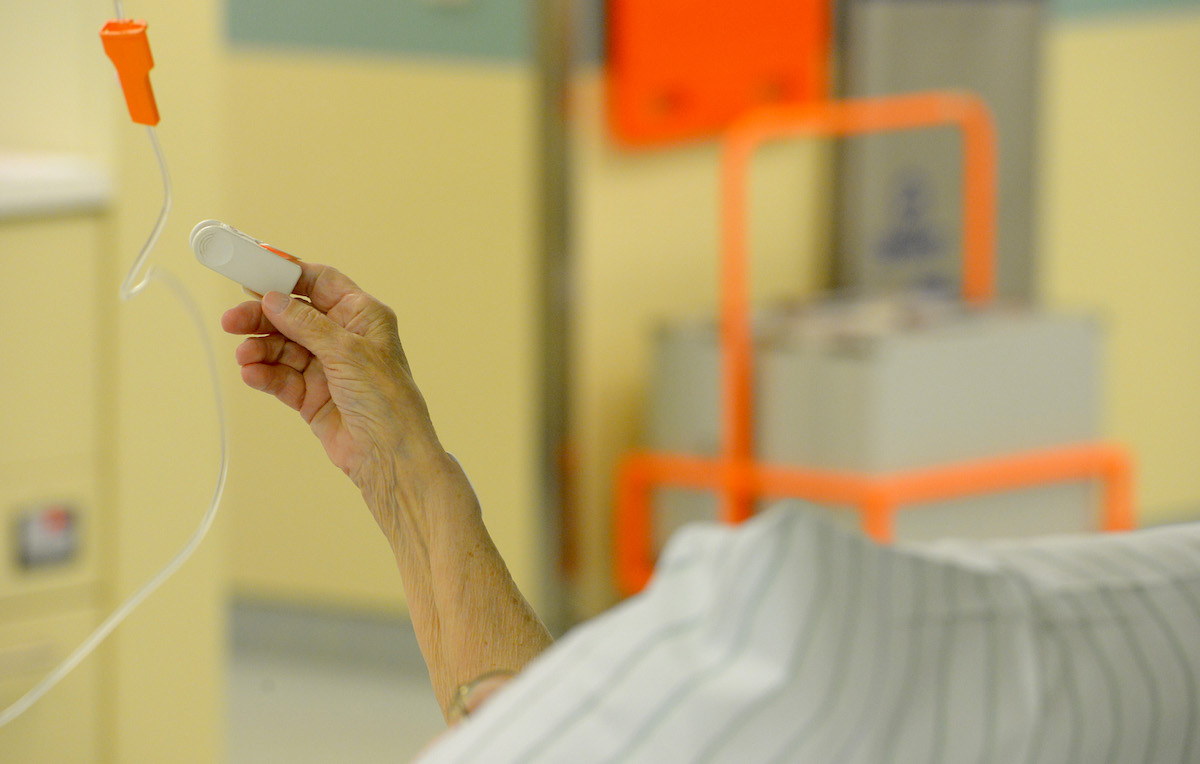 Une personne âgée hospitalisée pour la COVID-19 lève un bras.