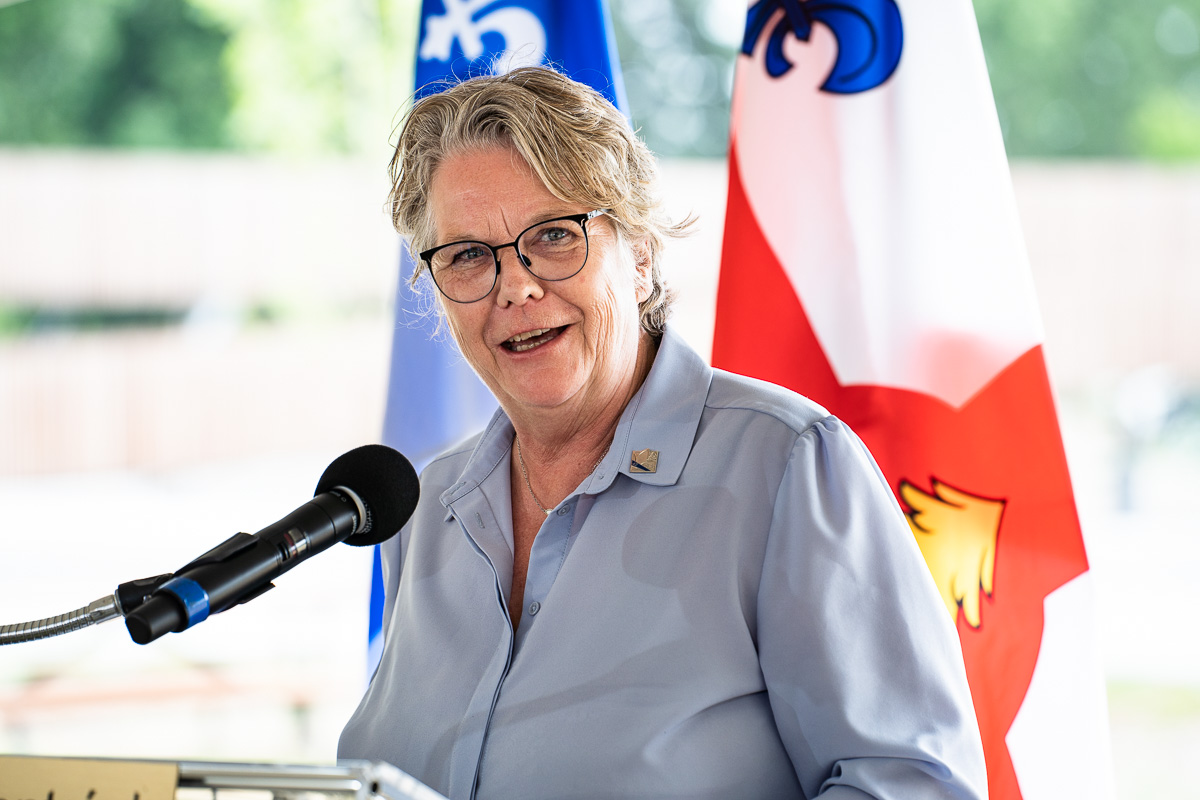 Chantal Rouleau, ministre responsable de la métropole, devant des drapeaux du Québec et de Montréal.