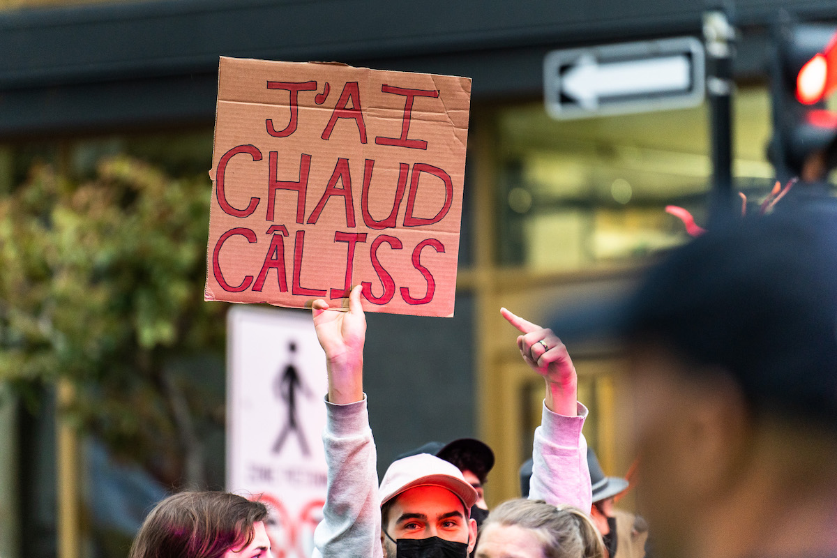 Un manifestant tient une pancarte disant «j'ai chaud câliss» pendant une grève pour le climat.