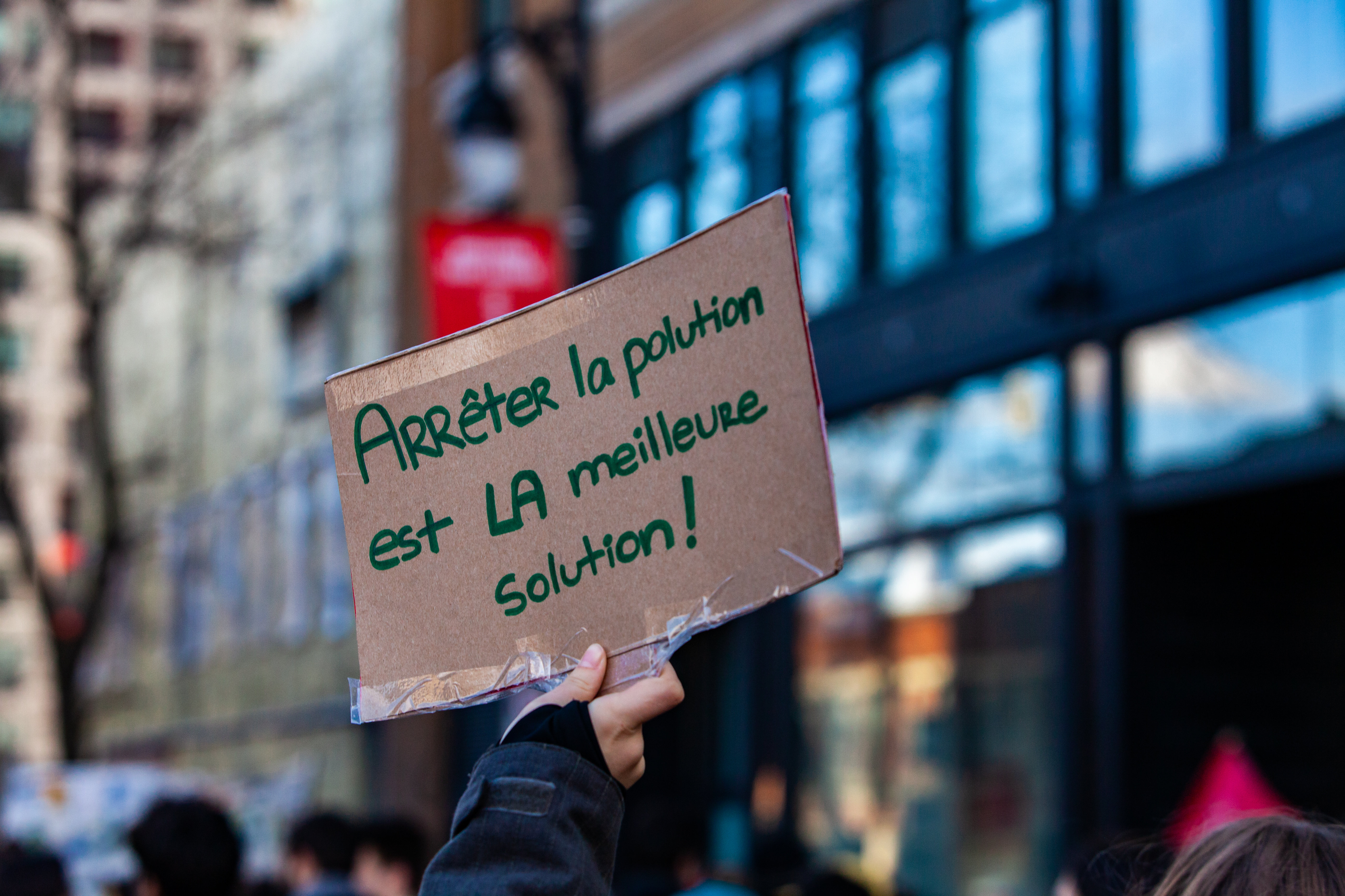 Une main tient une affiche disant «arrêter la pollution est la meilleure solution» lors d'une manifestation pour la lutte aux changements climatiques tenue à Montréal