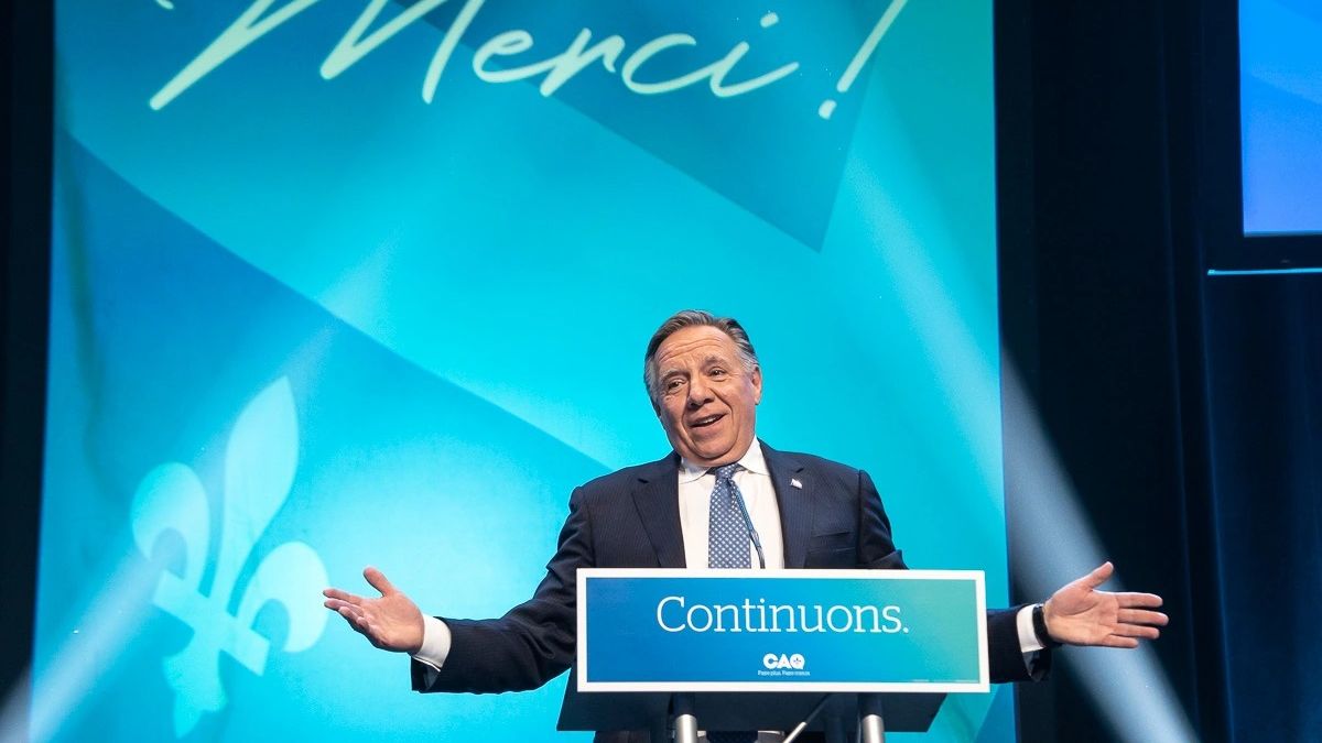 François Legault devant une pancarte affichant le mot "Merci" lors de sa réélection en novembre 2022.
