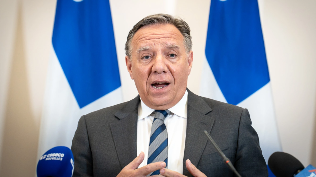 Le premier ministre François Legault devant deux drapeaux du Québec.