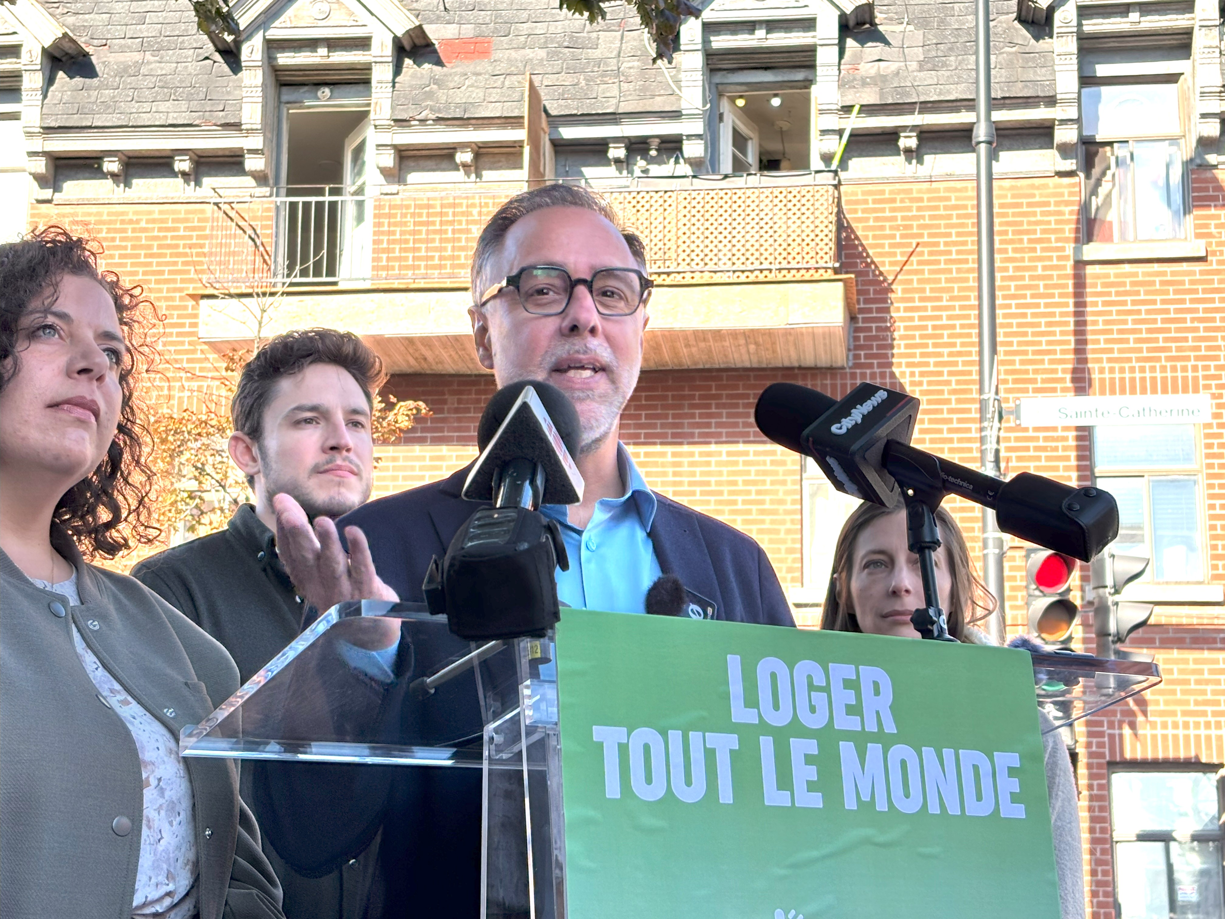 Luc Rabouin et des candidats de Projet Montréal dans Mercier-Hochelaga-Maisonneuve devant une maison de chambres.