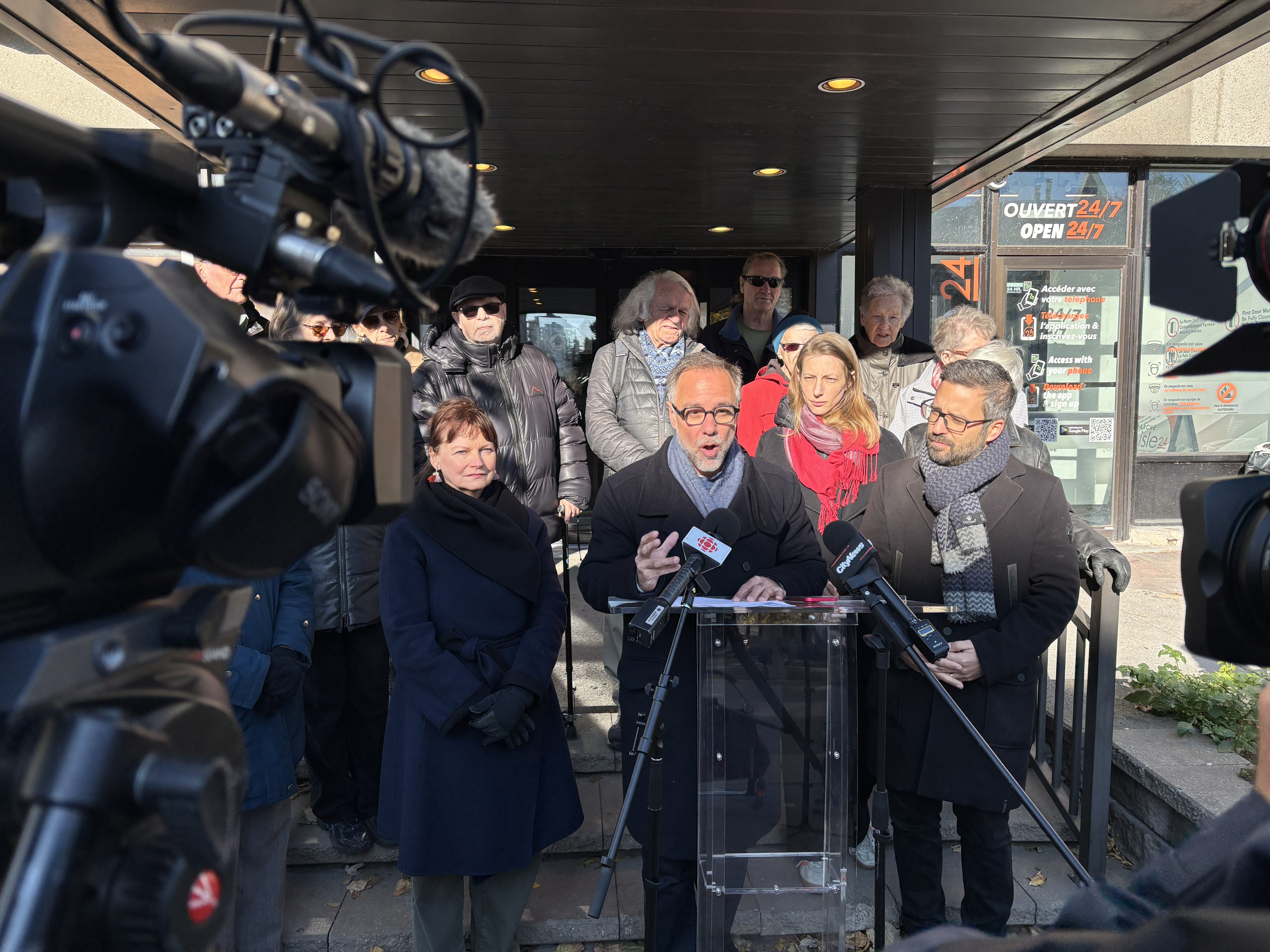 Luc Rabouin et Robert Beaudry devant la Résidence Mont-Carmel, accompagnés de plusieurs résidents.