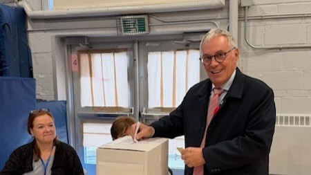 John Belvedere dépose son bulletin de vote lors des élections municipales de 2025 à Pointe-Claire.