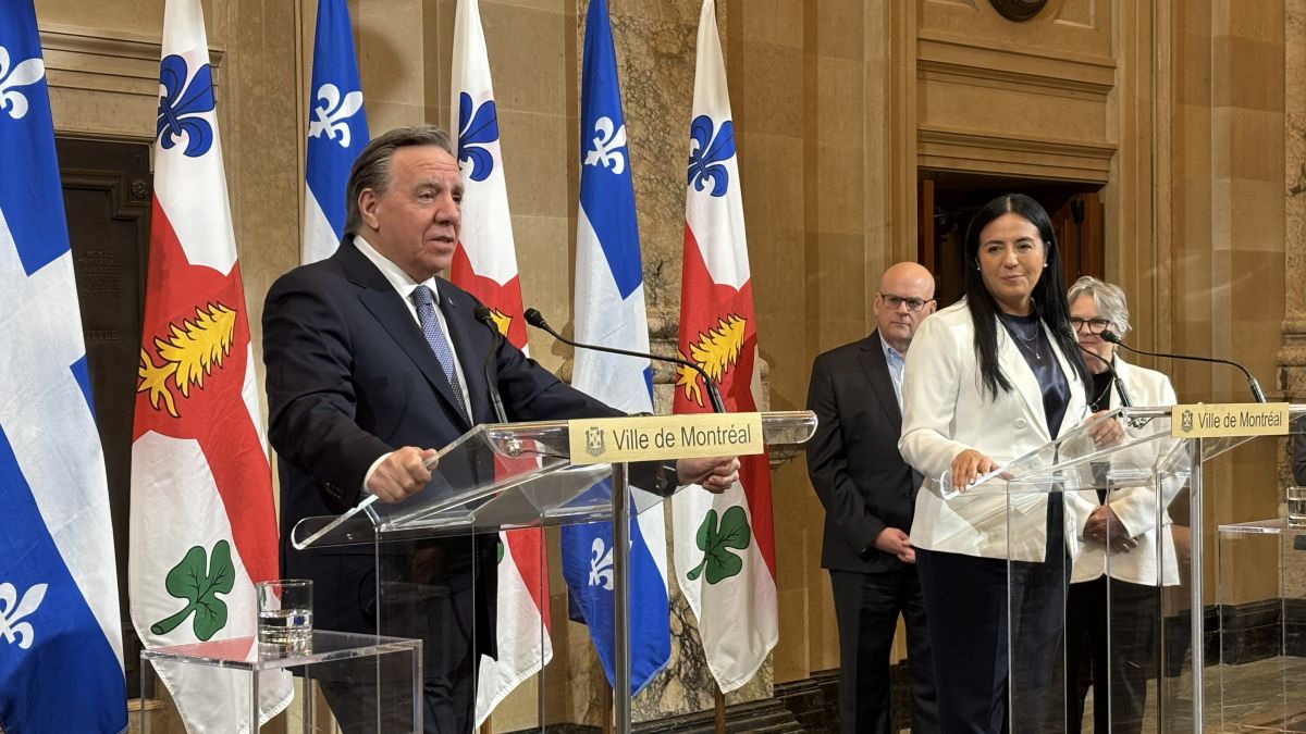 François Legault et Soraya Martinez Ferrada debouts devant des drapeaux de Québec et de Montréal lors d'une conférence de presse.