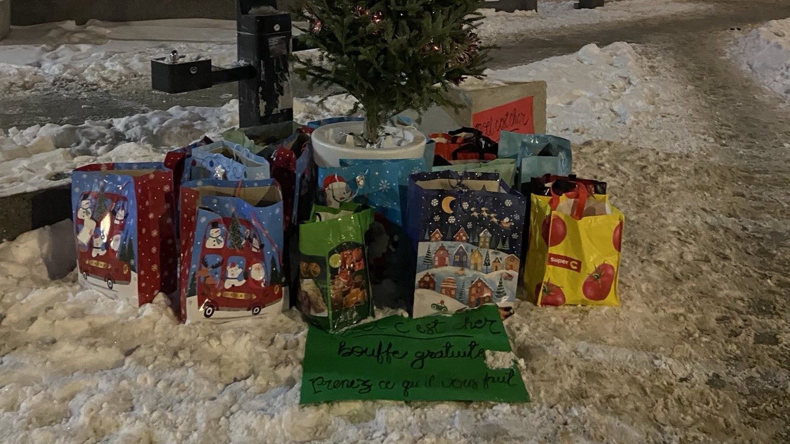 Des sacs de nourriture volée au Métro Beaulieu Laurier sont déposés au pied d'un sapin de Noël.