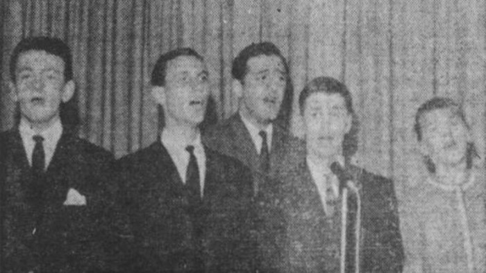 Photo numérisée en noir et blanc des cinq membres fondateurs du collectif Les Bozos qui se donnent en spectacle dans leur boîte à chanson Chez Bozo.