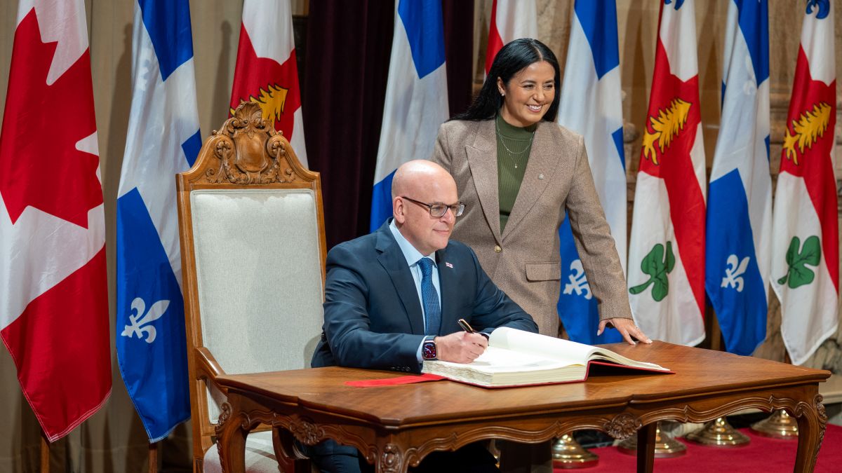 Claude Pinard signe son assermentation comme président du comité exécutif de Montréal accompagné de la mairesse Soraya Martinez Ferrada.