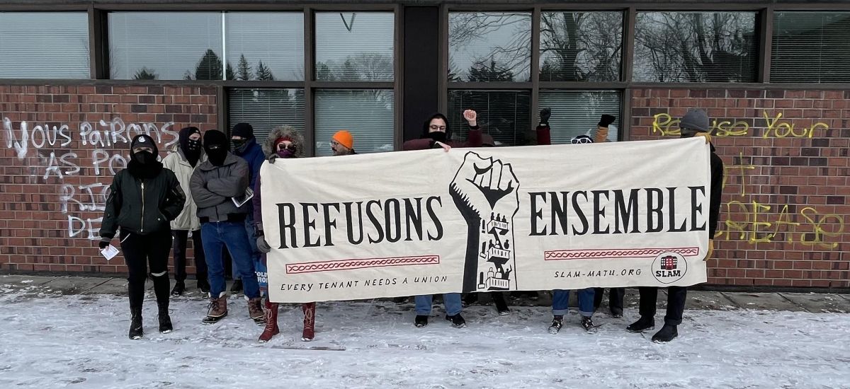 Une dizaine de manifestants du SLAM tiennent une banderole montrant un poing en l'air avec les mots "refusons ensemble" lors d'une manifestation aux bureaux du Tribunal administratif du logement.
