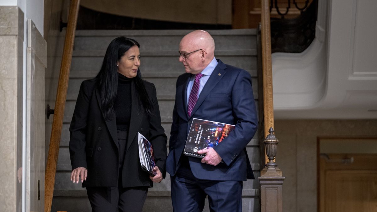 Soraya Martinez Ferrada et Claude Pinard descendent les marches à l'intérieur de l'hôtel de ville. Ils tiennent des copies du budget de Montréal 2026.