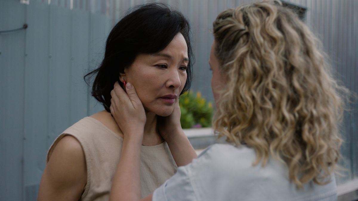 Camille tient le visage de Feng Xia dans une scène du film Montréal, ma belle.