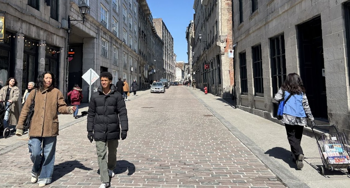 Des personnes marchent dans la rue sur le pavé de la rue Saint-Paul, après les travaux de réaménagement qui en ont fait une rue partagée.